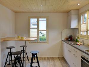 a kitchen with two bar stools and a small table at Holiday Home Chalet Dori by Interhome in Interlaken