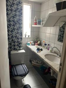 y baño con aseo y lavamanos. en Quarto aconchegante na casa de vovó modalidade guest house, en Recife