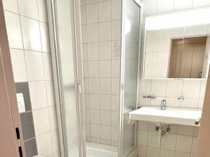 La salle de bains est pourvue d'une douche, d'un lavabo et d'un miroir. dans l'établissement Apartment Blumenweg 4-412 by Interhome, à Engelberg