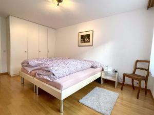 - une chambre avec un lit et une chaise dans l'établissement Apartment Blumenweg 4-412 by Interhome, à Engelberg