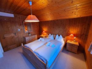 a bedroom with a large bed in a wooden room at Apartment Lieptgas by Interhome in Lenzerheide