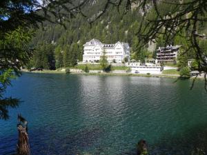 a large house sitting on the side of a lake at Apartment Alpes et Lac 2 by Interhome in Champex