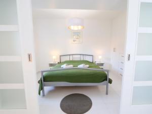 1 dormitorio con 1 cama verde y 2 mesitas de noche en Holiday Home Posázaví by Interhome, en Jílové u Prahy