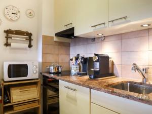 a kitchen with a sink and a microwave at Apartment Grand Hôtel B47 by Interhome in Villars-sur-Ollon