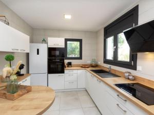 uma cozinha com electrodomésticos brancos e uma bancada de madeira em Villa Gaia by Interhome em Miami Platja