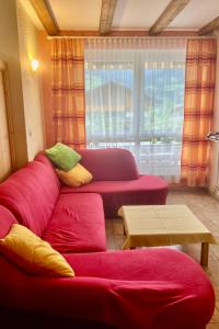 uma sala de estar com um sofá vermelho e uma mesa em Apartment Sonnenhang by Interhome 