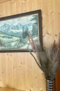 a vase filled with feathers in front of a painting at Apartment Sonnenhang by Interhome 