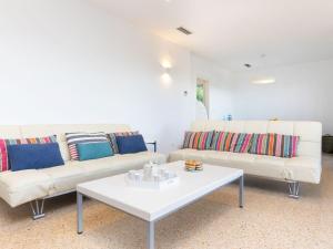 una sala de estar con 2 sofás blancos y una mesa. en Holiday Home Can Delmas by Interhome, en Pals