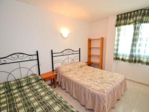 1 dormitorio con 2 camas y ventana en Apartment Aguamarina-4 by Interhome en La Pineda