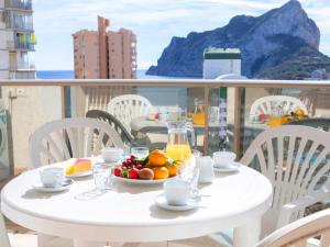 een witte tafel met een fruitschaal op een balkon bij Apartment Esmeralda Suites-2 by Interhome in Calpe