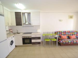 uma cozinha com uma mesa e um sofá numa cozinha em Apartment Albeniz-1 by Interhome em La Pineda