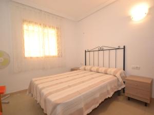 um quarto branco com uma cama e uma janela em Apartment Albeniz-1 by Interhome em La Pineda