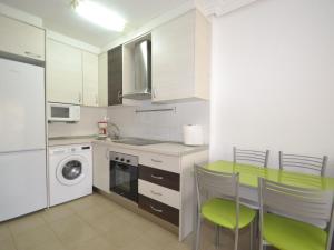 uma cozinha com uma mesa e cadeiras e uma máquina de lavar roupa em Apartment Albeniz-1 by Interhome em La Pineda