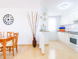 a white kitchen with a table and a vase on the floor at Apartment Jardimar by Interhome in Moncófar