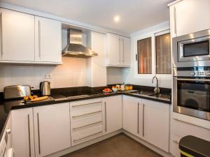 une cuisine blanche avec des armoires et des appareils blancs dans l'établissement Apartment Deltamar-2 by Interhome, à Jávea