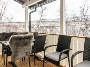 a porch with chairs and a table with a view of snow at Holiday Home Willa kiiruna by Interhome in Kilpisjärvi