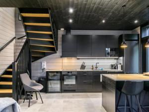 a kitchen with stainless steel appliances and a staircase at Holiday Home Villa arcus a by Interhome in Pelkosenniemi