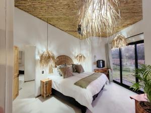 a bedroom with a large bed in a room with windows at Buff & Fellow Eco Cabins in George