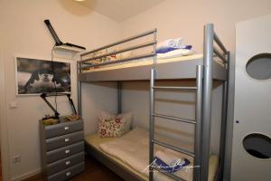 ボルクムにあるVilla-Pirola-Wohnung-5のベッドルーム1室(二段ベッド2台、ドレッサー付)