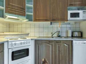 a kitchen with wooden cabinets and white appliances at Holiday Home Hopeatalo b by Interhome in Pyhätunturi