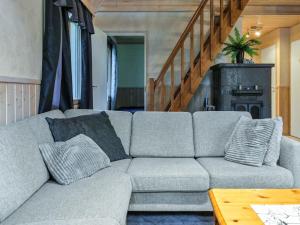 a gray couch with pillows in a living room at Holiday Home Hopeatalo b by Interhome in Pyhätunturi