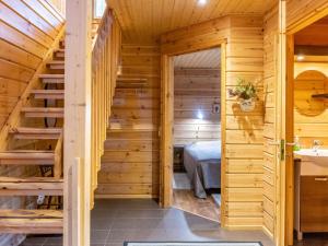 Dormitorio en cabaña de madera con cama y escalera en Holiday Home Tulikettu 1 by Interhome, en Pyhätunturi