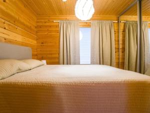 Schlafzimmer mit einem Bett und einem Fenster in der Unterkunft Holiday Home Pyhäkoti a- karhu by Interhome in Pyhätunturi