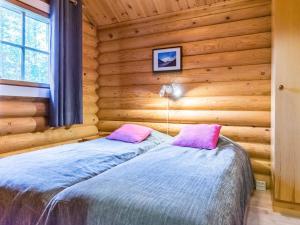 1 dormitorio con 1 cama en una cabaña de madera en Holiday Home Pyhäkolo by Interhome en Pyhätunturi