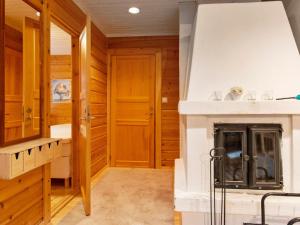ein Wohnzimmer mit Kamin und Holzwänden in der Unterkunft Holiday Home Saukonpiilo 1 by Interhome in Pyhätunturi