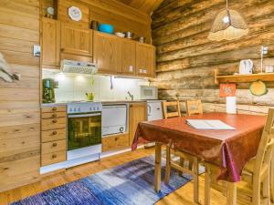 a kitchen with a table and a stove at Holiday Home Kuopiokero by Interhome in Pyhätunturi