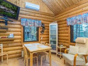 una sala da pranzo con tavolo e sedie in una baita di tronchi di Holiday Home Munkero by Interhome a Pyhätunturi