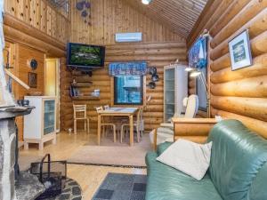 un soggiorno con divano e tavolo in una baita di tronchi di Holiday Home Munkero by Interhome a Pyhätunturi