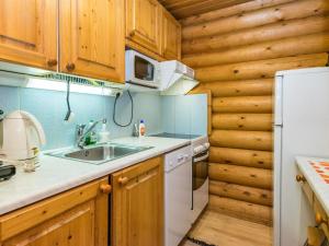 una cucina con mobili in legno e un frigorifero bianco di Holiday Home Munkero by Interhome a Pyhätunturi Altre 12 foto