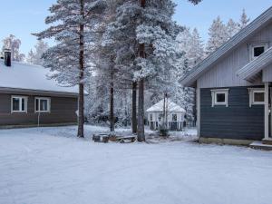 a house with a snow covered yard next to a house at Holiday Home Aslakin helmi a by Interhome in Pyhätunturi
