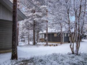 a house covered in snow next to a yard at Holiday Home Aslakin helmi a by Interhome in Pyhätunturi