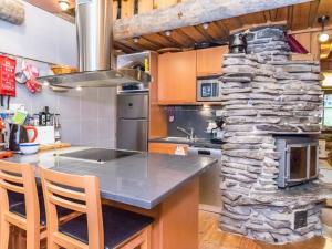 uma cozinha com um fogão de pedra e um balcão com cadeiras em Holiday Home Satukero a 2 by Interhome em Pyhätunturi
