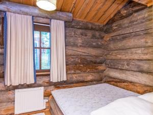 um quarto com uma cama num chalé de madeira em Holiday Home Satukero a 2 by Interhome em Pyhätunturi