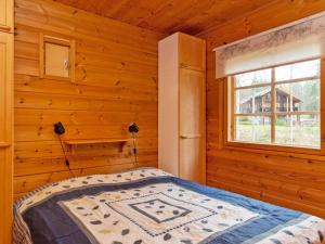 a bedroom with a bed in a log cabin at Holiday Home Ummelo by Interhome in Pyhätunturi +8 photos