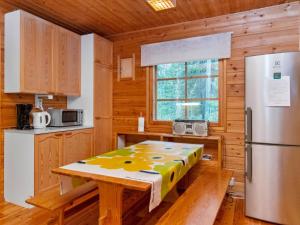 a kitchen with a table and a refrigerator at Holiday Home Ummelo by Interhome in Pyhätunturi