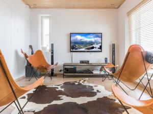sala de estar con sillas y TV de pantalla plana en Holiday Home Holy rock by Interhome en Pyhätunturi