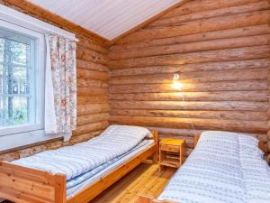 a cabin with two beds in a room with wooden walls at Holiday Home Hovimartti by Interhome in Pyhätunturi