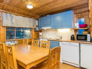 cocina con mesa de madera y armarios azules en Holiday Home by Interhome, en Pyhätunturi