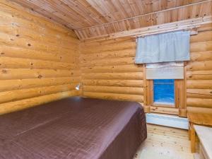 um quarto com uma cama num chalé de madeira em Holiday Home Kuukkelin tupa 2 by Interhome em Pyhätunturi