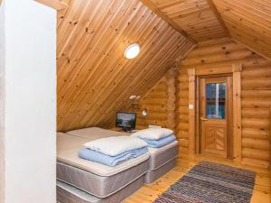 Duas camas num quarto de madeira com paredes de madeira em Holiday Home Kuukkelin tupa 2 by Interhome em Pyhätunturi