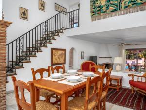 une salle à manger avec une table, des chaises et un escalier dans l'établissement Villa Luna by Interhome, à Sitio de Calahonda