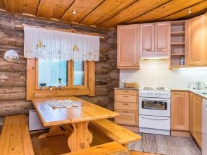 een keuken met houten kasten en een houten tafel bij Holiday Home Kiimaselän hovi- kettula by Interhome in Pyhätunturi