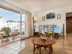 a living room with a table and a balcony at Apartment Albaniz by Interhome in Tossa de Mar