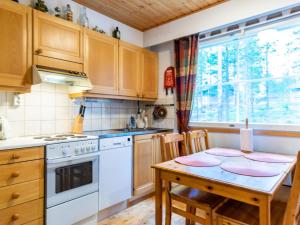 cocina con mesa y fogones horno superior en Holiday Home Oivanpyhä c 10 by Interhome en Pyhätunturi