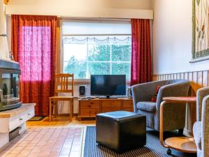sala de estar con TV y cortinas rojas en Holiday Home Oivanpyhä c 10 by Interhome en Pyhätunturi