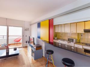 een keuken met kleurrijke kasten en een tafel en krukken bij Apartment Geminis by Interhome in Hospitalet de l'Infant